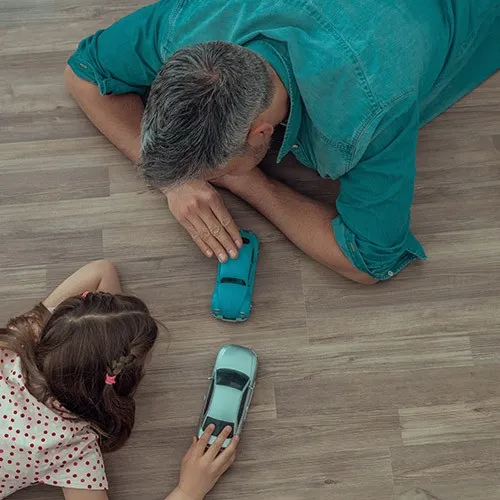 AfterWaterproofInstallation Dad child playing with toy car | Hernandez Wholesale Flooring